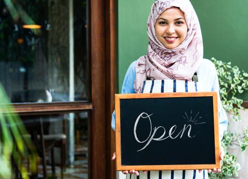 Islamic woman small business owner holding blackboard with smiling - 400103