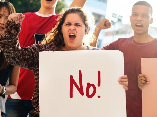 Closeup of angry teen girl protesting demonstration holding posters antiwar justice peace concept - 401489