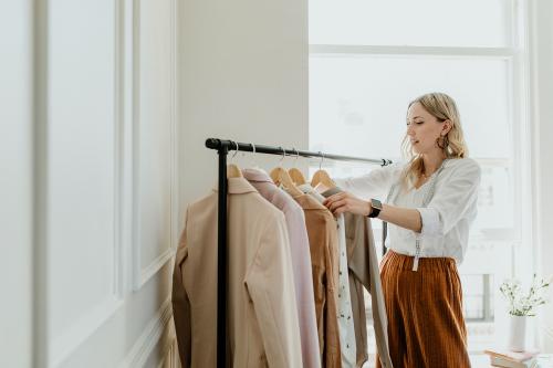 Fashion stylist sorting the clothing rack - 1211556