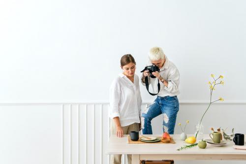 Blogger photographing the plate decor on the dining table - 1212490