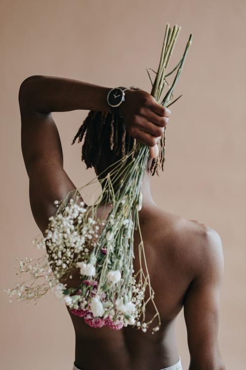 Black man carrying a bouquet of flowers on his back - 1213793