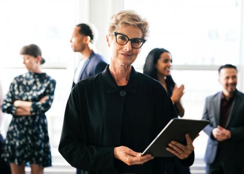 Happy empowering businesswoman holding a digital tablet - 1216772