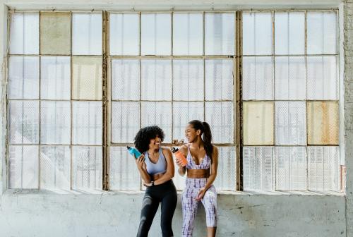 Sportive women talking in a gym while drinking water - 1222563