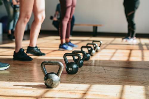 People standing by kettlebells in the gym - 1225138