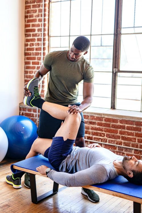 Trainer helping his student stretch - 1225159