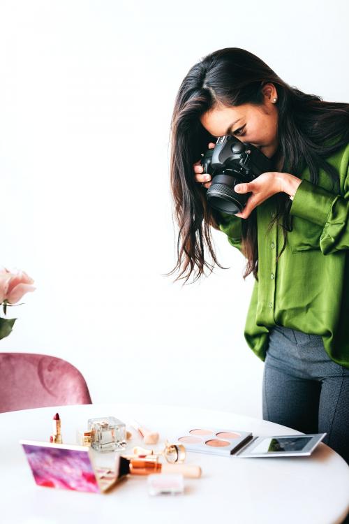 Female photographer shooting beauty products on the table - 1226528