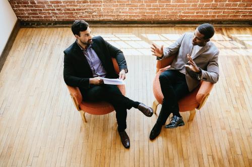 Businessmen talking and sitting on chairs - 1226709