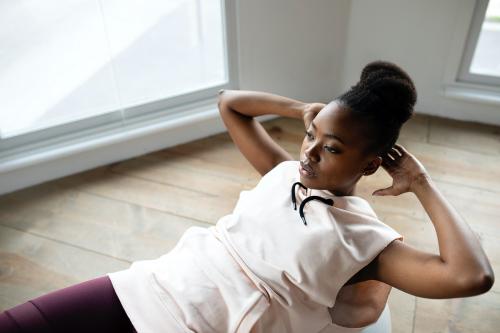 Black woman doing the sit-ups on a balance ball - 1226979