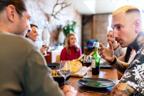 Friends having a serious conversation at a dinner party - 1227003