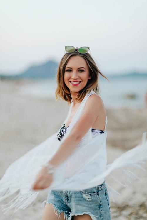 Cheerful woman at the beach - 1228354