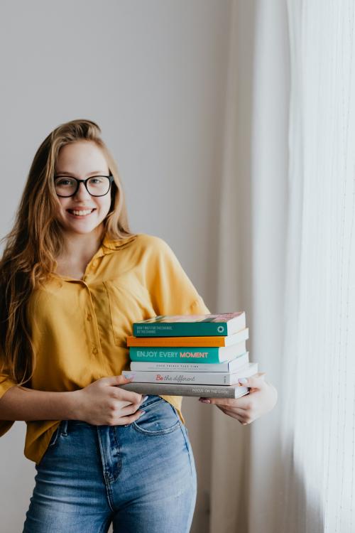 Cheerful blond girl carrying books - 937448