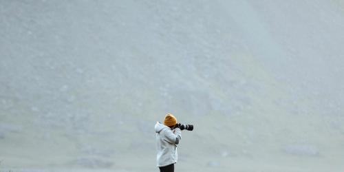 Photographer on a green hill at the Stokksnes peninsula in Southeast Iceland - 1206001