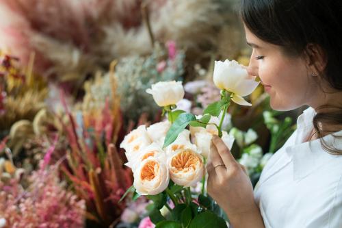 Woman smelling a bouquet of Romantic Vuvuzela Roses. - 1207583