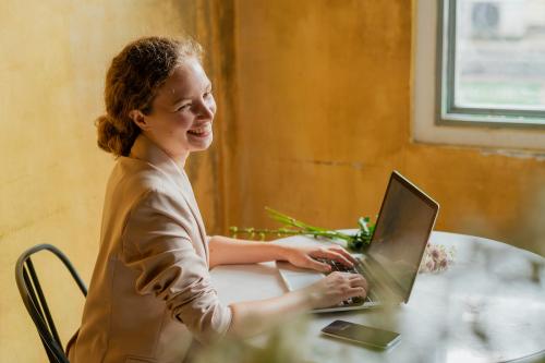 Beautiful businesswoman working on her laptop at a cafe - 1207781