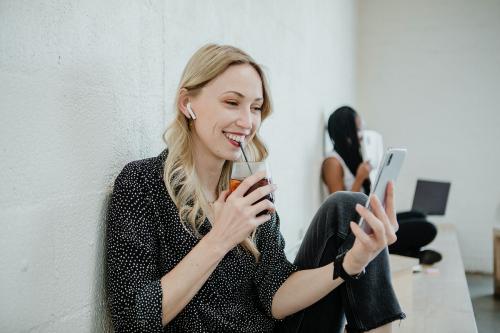 Cheerful woman listening to music from her phone - 1208469