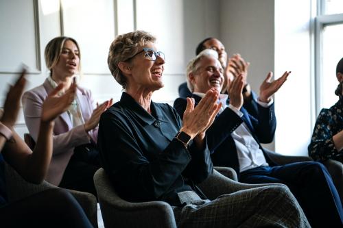 Happy business people applauding in a seminar - 1208689