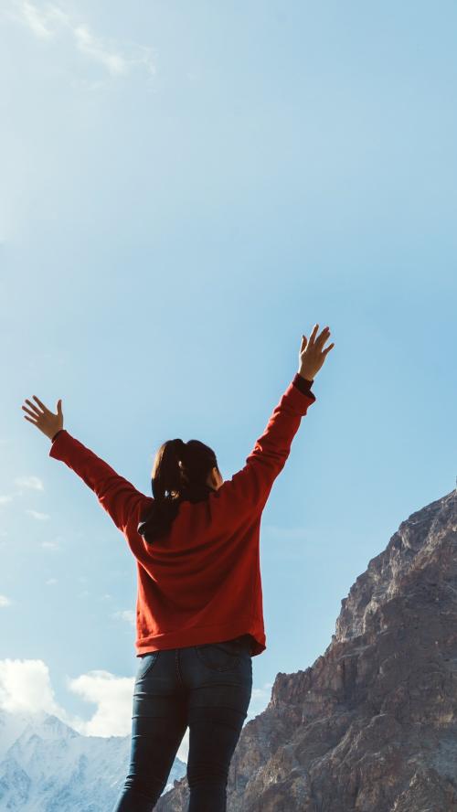 Woman standing under a bright blue sky mobile wallpaper - 1214215