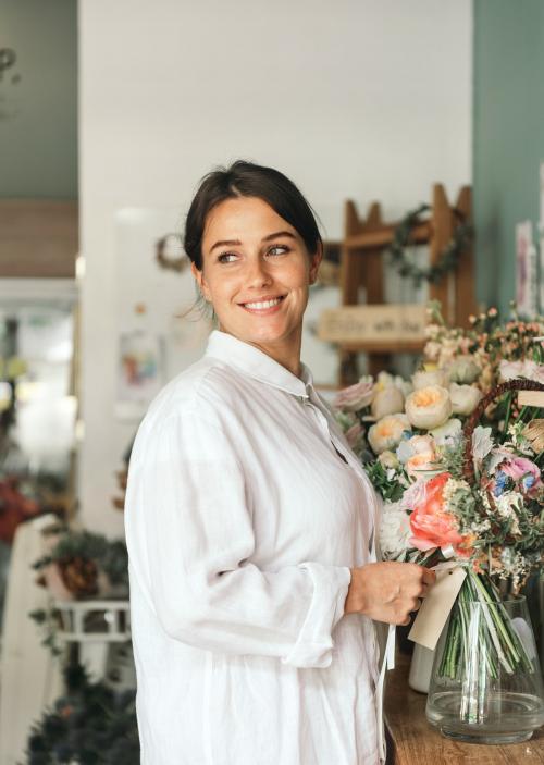 Cheerful woman in the flower shop - 1207500