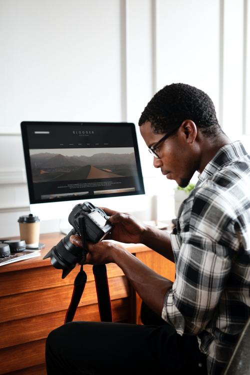 African American photographer working on his desk - 1209067