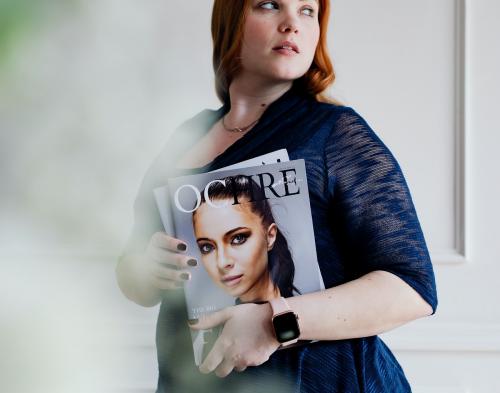 Woman wearing a smartwatch and holding a magazine - 1209093