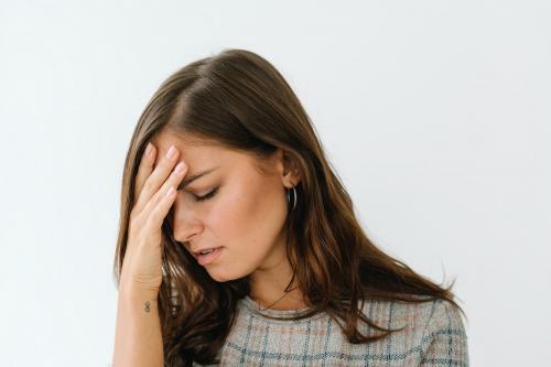 Stressed woman in a gray plaid dress - 1212605