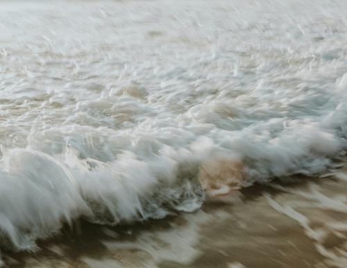 Frothy beach waves in motion - 1215616