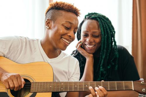 Happy lesbian couple enjoying playing music together - 1205435