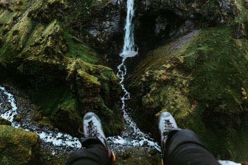 Pair of legs with a view of a waterfall - 1205934