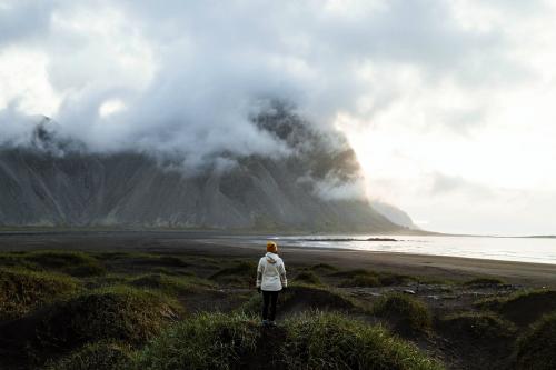 Photographer on a green hill at the Stokksnes peninsula in Southeast Iceland - 1205953