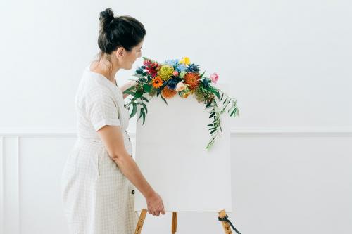 Florist decorating a sign with flowers - 1207281