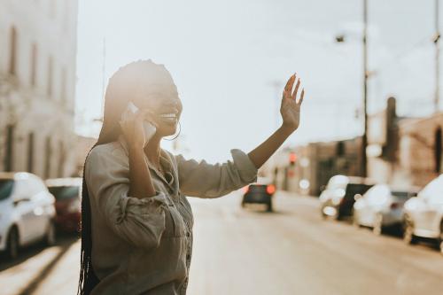 Black woman on the phone hailing a cab - 1208358