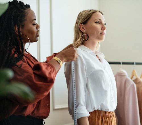 Fashion stylist measuring a customers shoulders - 1211544