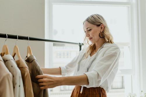 Fashion stylist sorting the clothing rack - 1211567