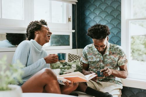 Happy black couple reading a book at home - 1211632