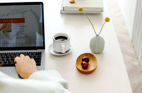 Woman using a laptop on a wooden table - 1212504