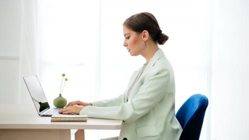 Businesswoman typing on her laptop on a wooden table - 1212632