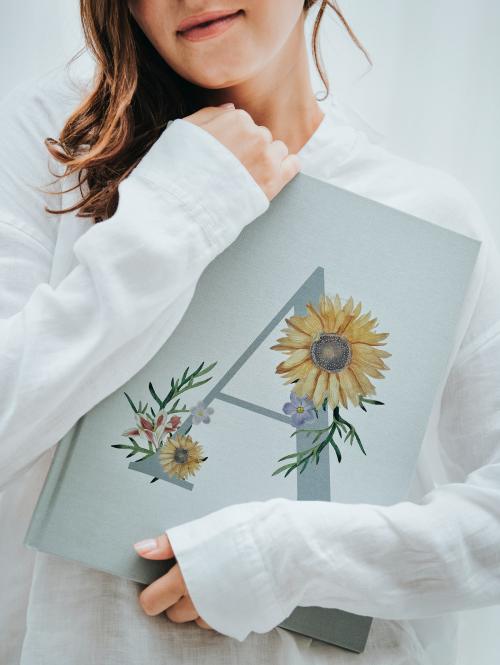 Cheerful woman holding a gray book - 1212669