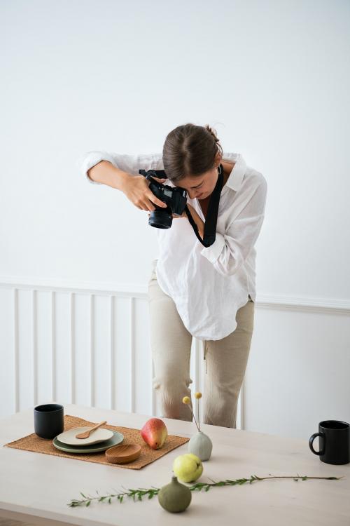 Blogger photographing the plate decor on the dining table - 1212728