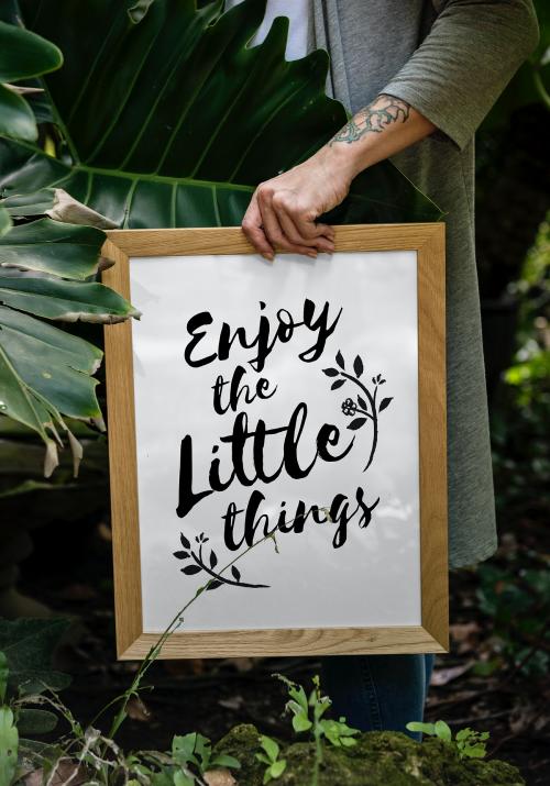 Closeup of woman's hand holding a Picture Frame with a quote on it - 295885