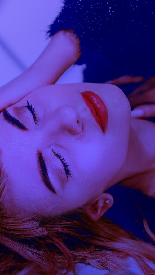 Brown hair woman in a black fluffy sweater lying on a floor - 1216414