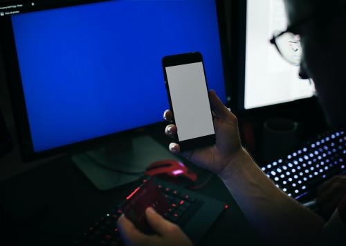 Closeup of hands holding mobile phone with computer laptop background - 49879