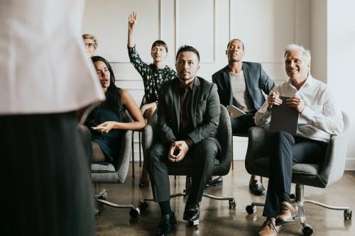 Business people in a seminar raising their hands - 1216594