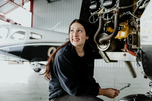 Female aviation technician repairing the motor - 1202210