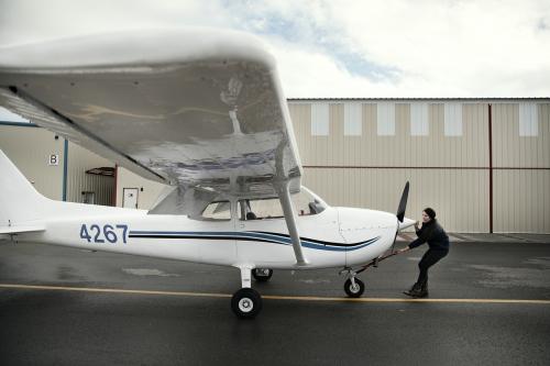 Aviation engineer checking a propeller plane - 1202289