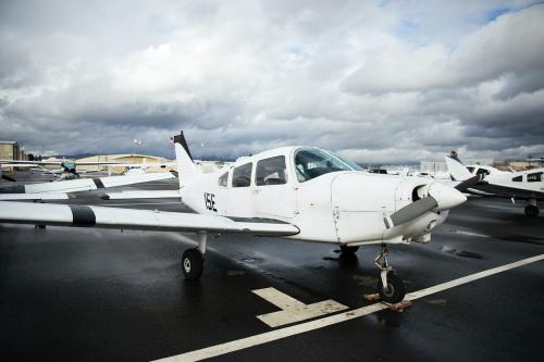 Front propellor plane parked at an airport - 1202312