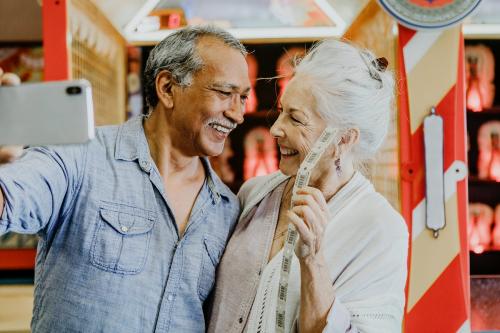 Happy senior couple taking a selfie with raffle tickets - 1202606