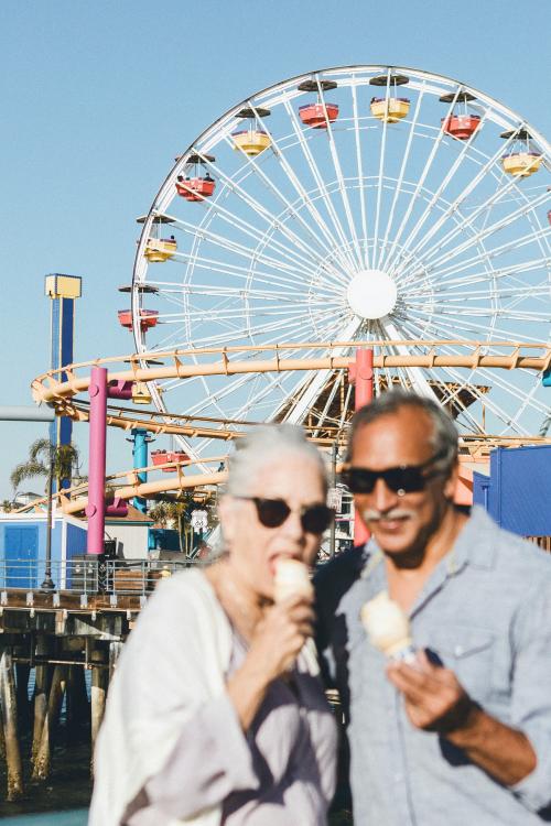 Smiling senior couple having ice cream at Santa Monica Pier - 1202709