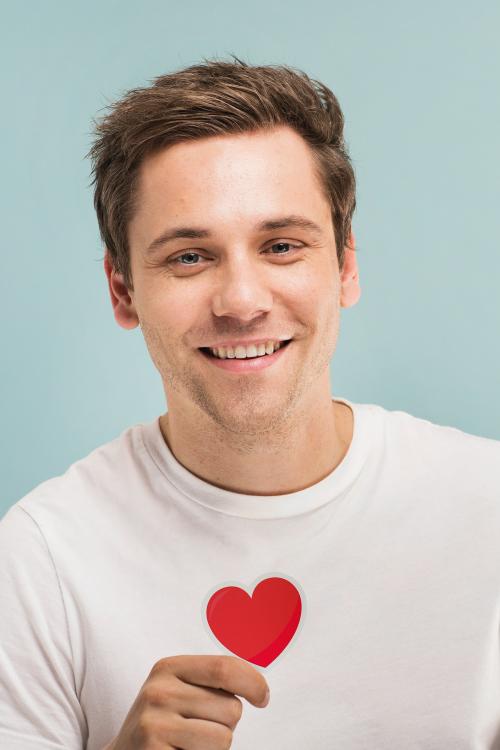 Cheerful man holding a heart icon - 1203170