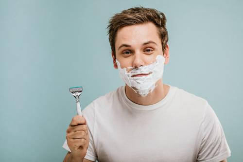 Young man shaving his beard - 1203242