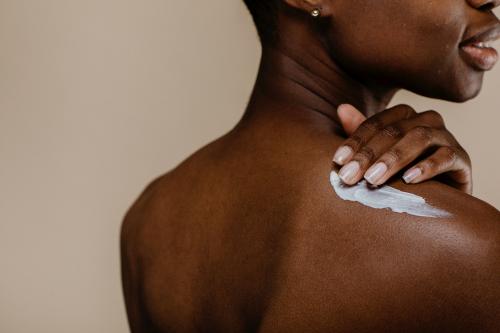 Black woman applying body cream - 1203300